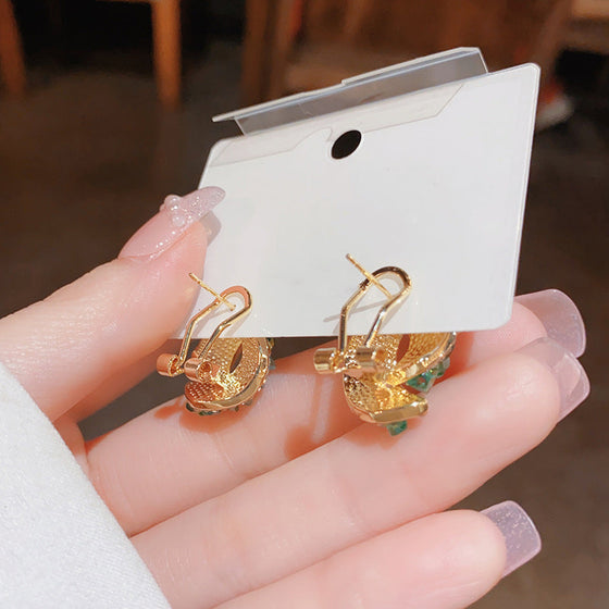 Gröna dekorerade spänneörhängen